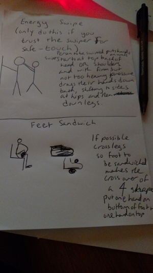 two stick figure images: the top one with an explanation of Energy Swipe has two stick figures one with its hands up on a wall in police frisk pose and the person behind it with their hands on the back of their head; the bottom one labeled Feet Sandwich has a picture of a stick figure on a chair crossing one of their legs over their lap in a 4 shape. THe close up doodle shows a rough sketh of a foot with two dots marking hands on the top and bottom of the foot to show where hands should be