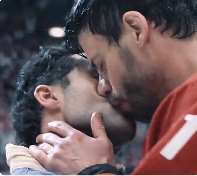 Blurry screengrab of the Scott Kiss center ice kiss