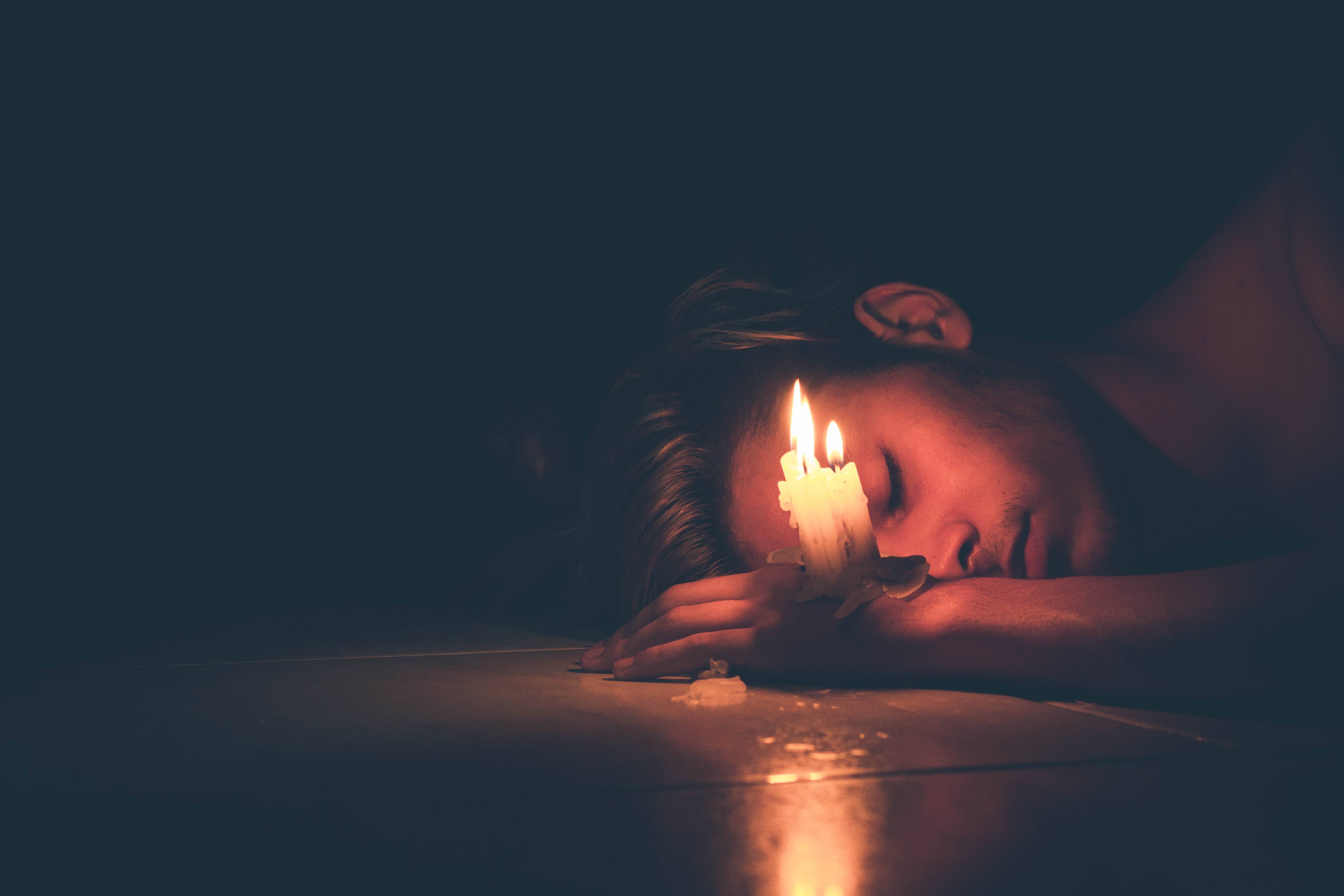 A man sleeping by a candle